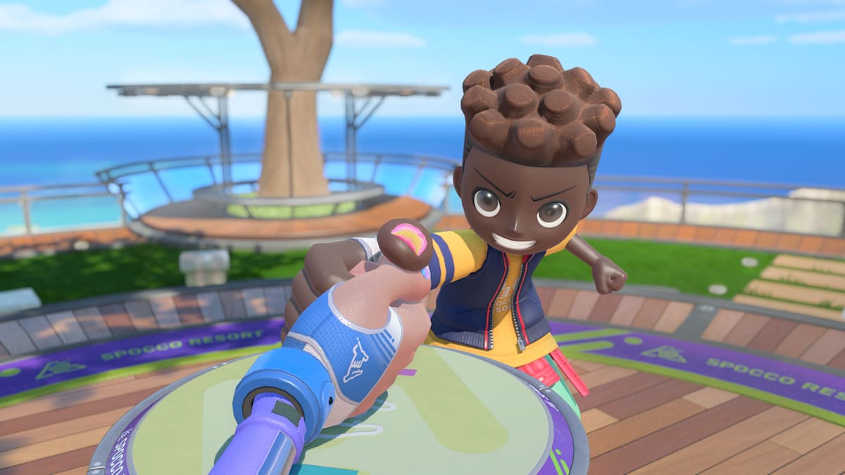 A first-person view of a thumb-wrestling grip against a grinning opponent, with “Spocco Resort” on the table