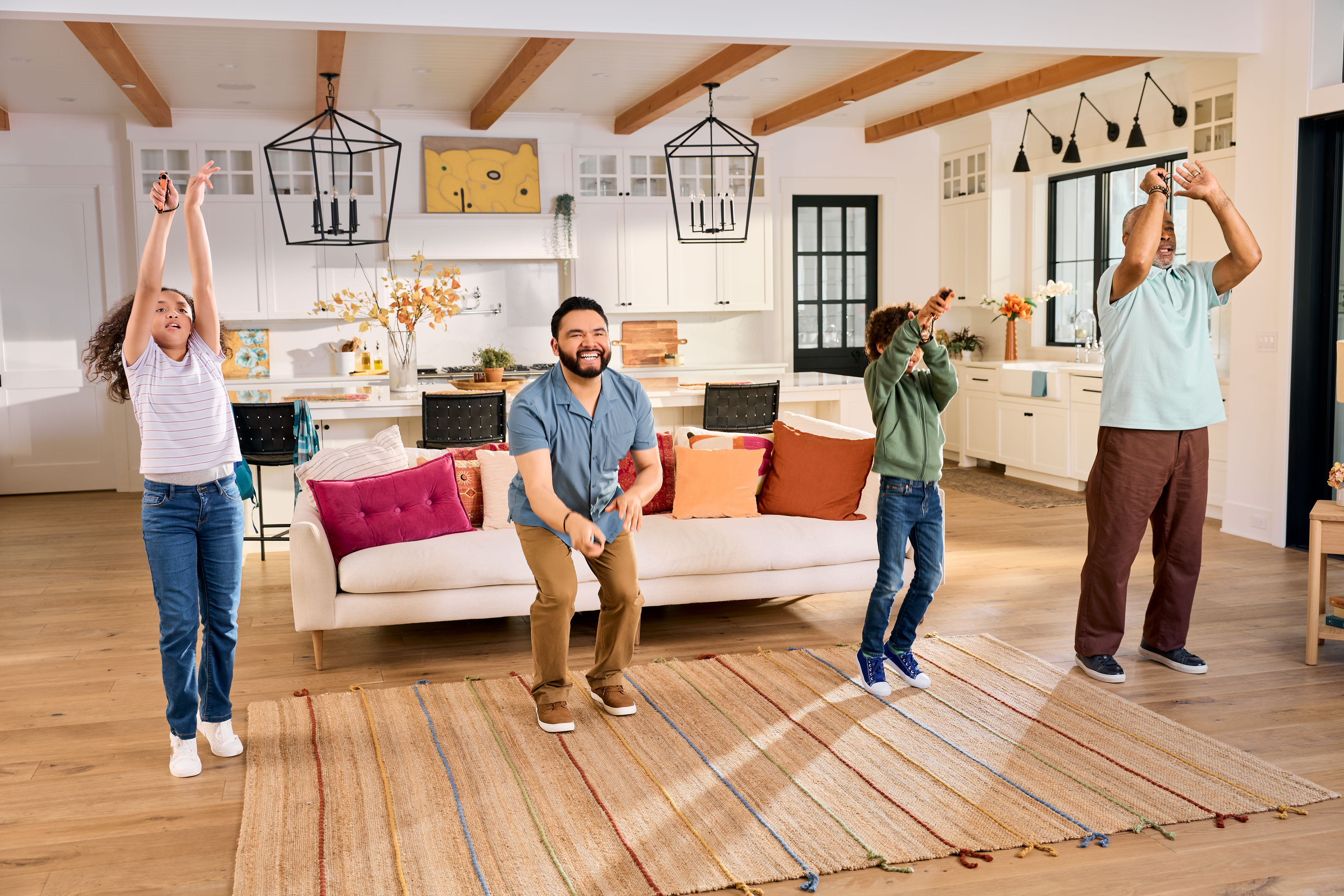 A family of four playing Nintendo Switch Sports Resort together in their living room, each holding up a Joy-Con 2 controller.
