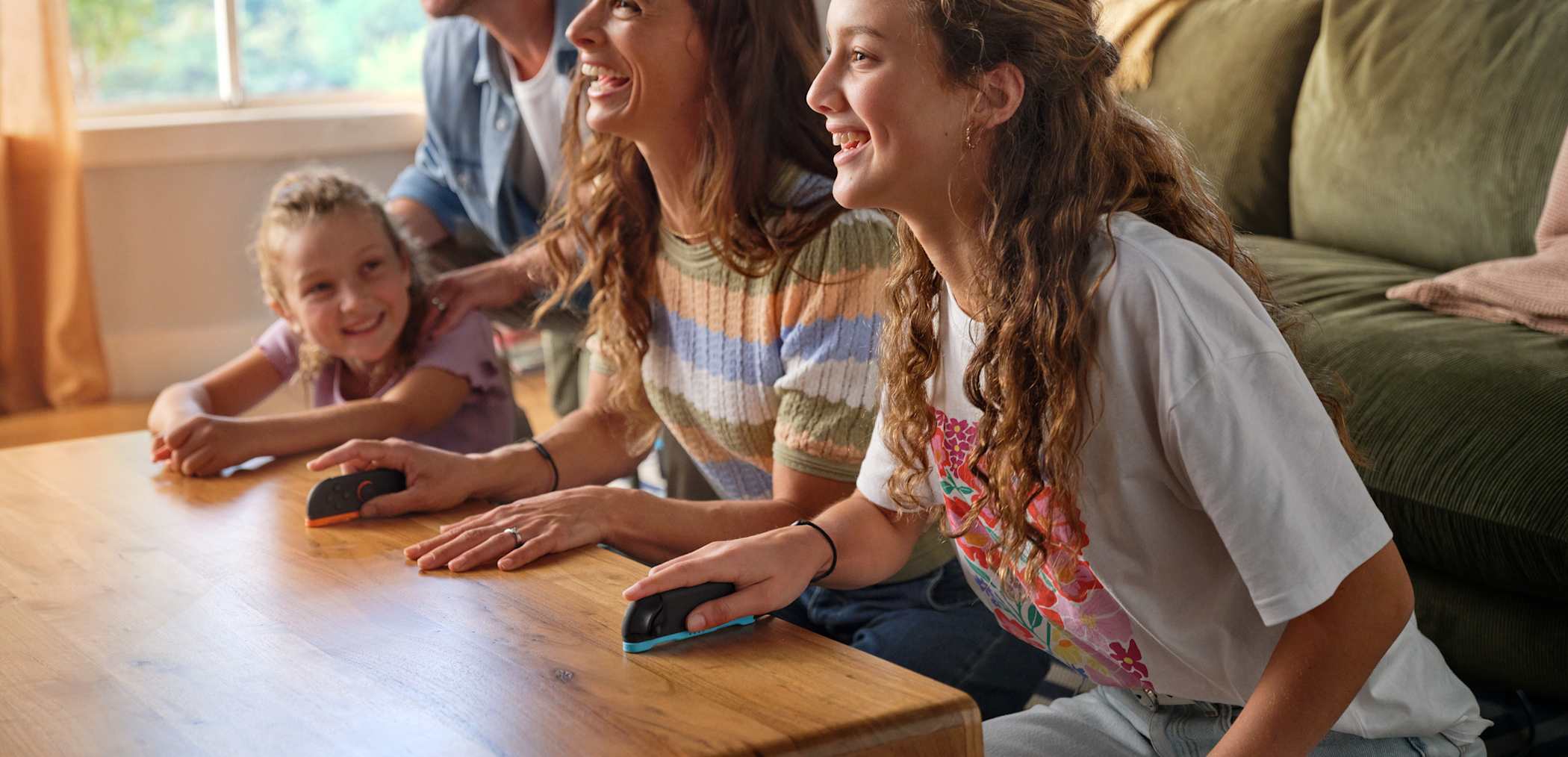 Una madre y su hija se ríen mientras juegan usando los controles del mouse Joy-Con 2.